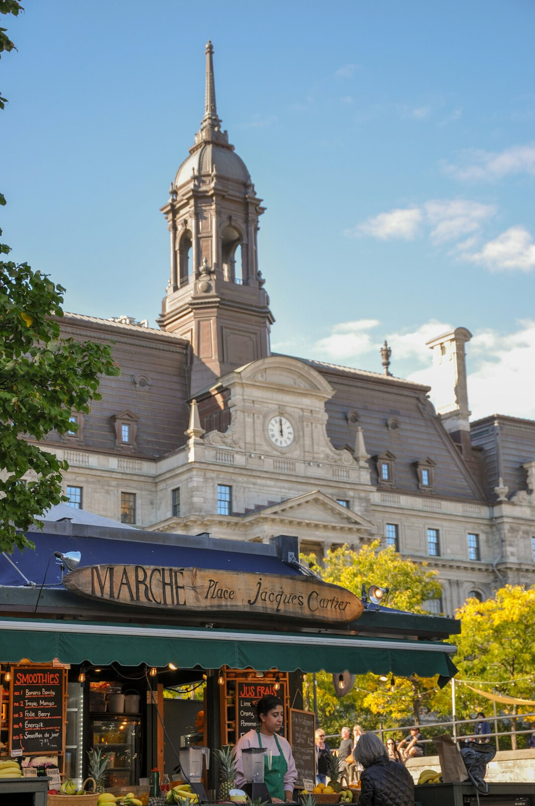 Busy outdoor farmers market street scene in Montreal with vendors and shoppers